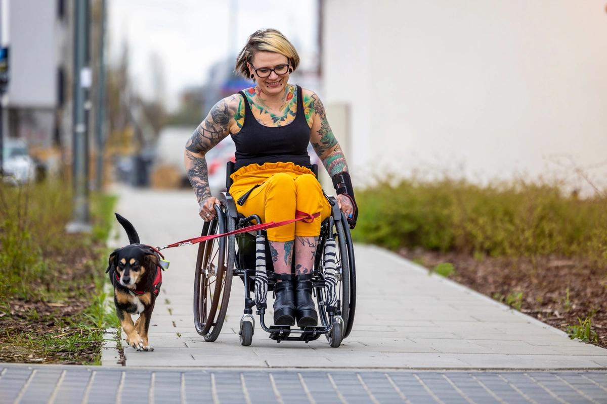 woman in wheelchair with dog outside
